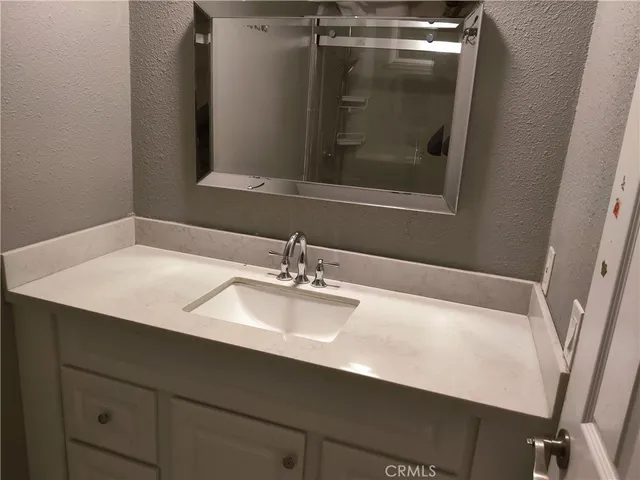 a bathroom with a sink vanity and a mirror