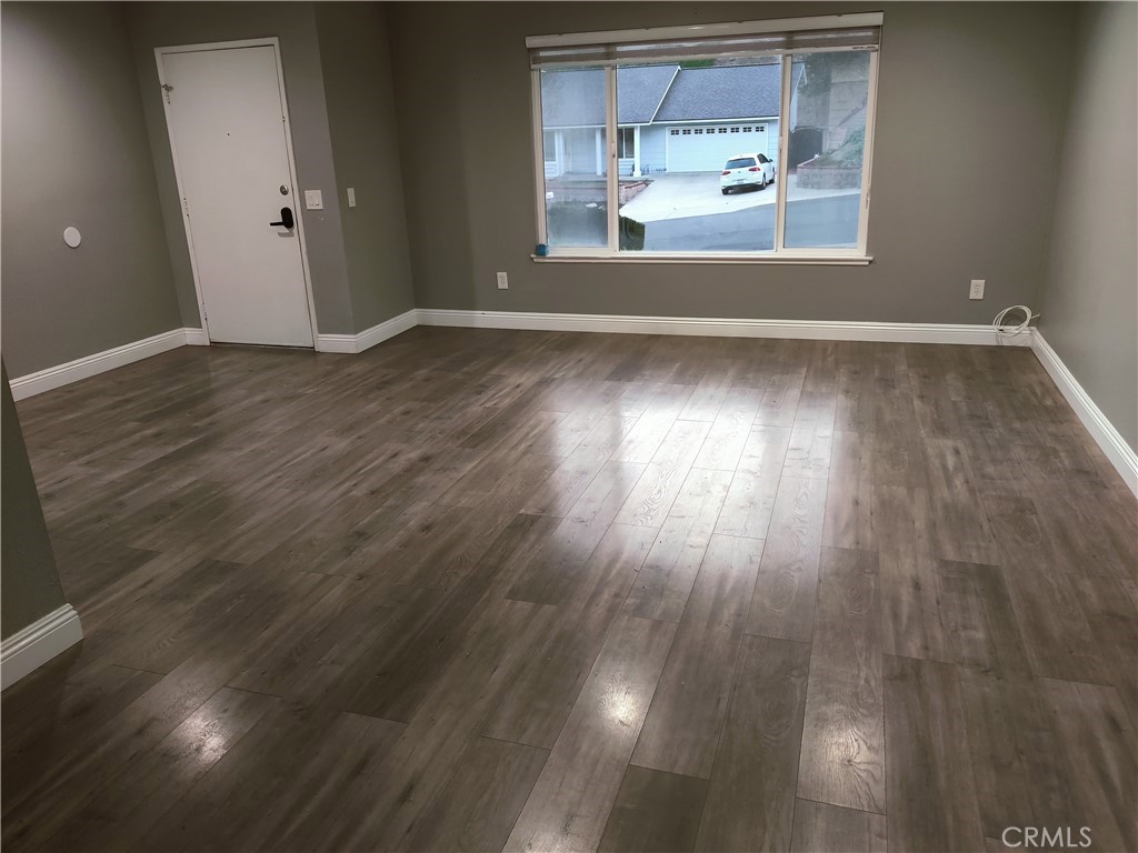 1806 Morning Canyon Road Diamond Bar, CA 91765 - Photo 3 of 16 an empty room with wooden floor cabinet and windows