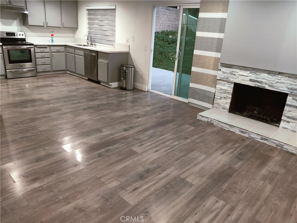 1806 Morning Canyon Road Diamond Bar, CA 91765 - Photo 6 of 16 a large kitchen with granite countertop a stove top oven a sink and a wooden floor