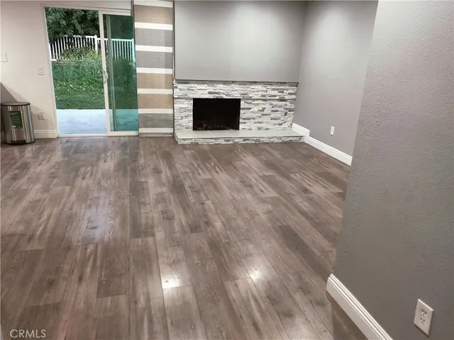 a view of a livingroom with wooden floor and a fireplace