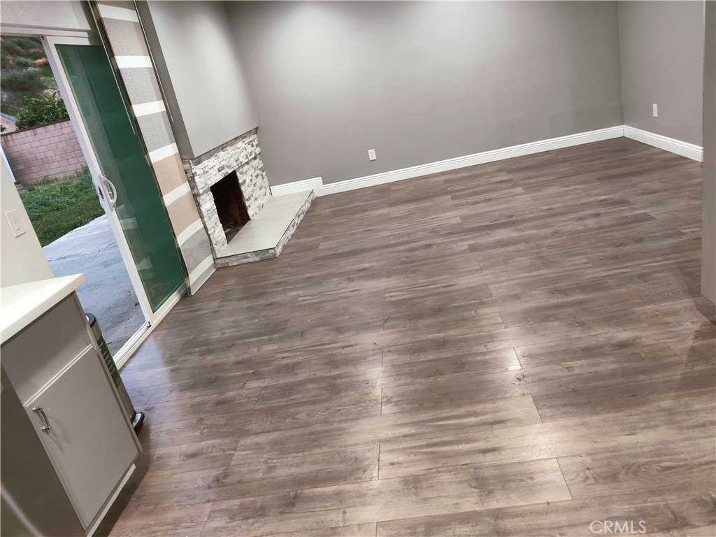 1806 Morning Canyon Road Diamond Bar, CA 91765 - Photo 8 of 16 a view of an empty room with wooden floor and a fireplace