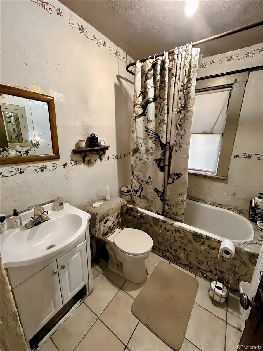 3935 Shoshone Street Denver, CO 80211 - Photo 12 of 14 a bathroom with a sink toilet and shower