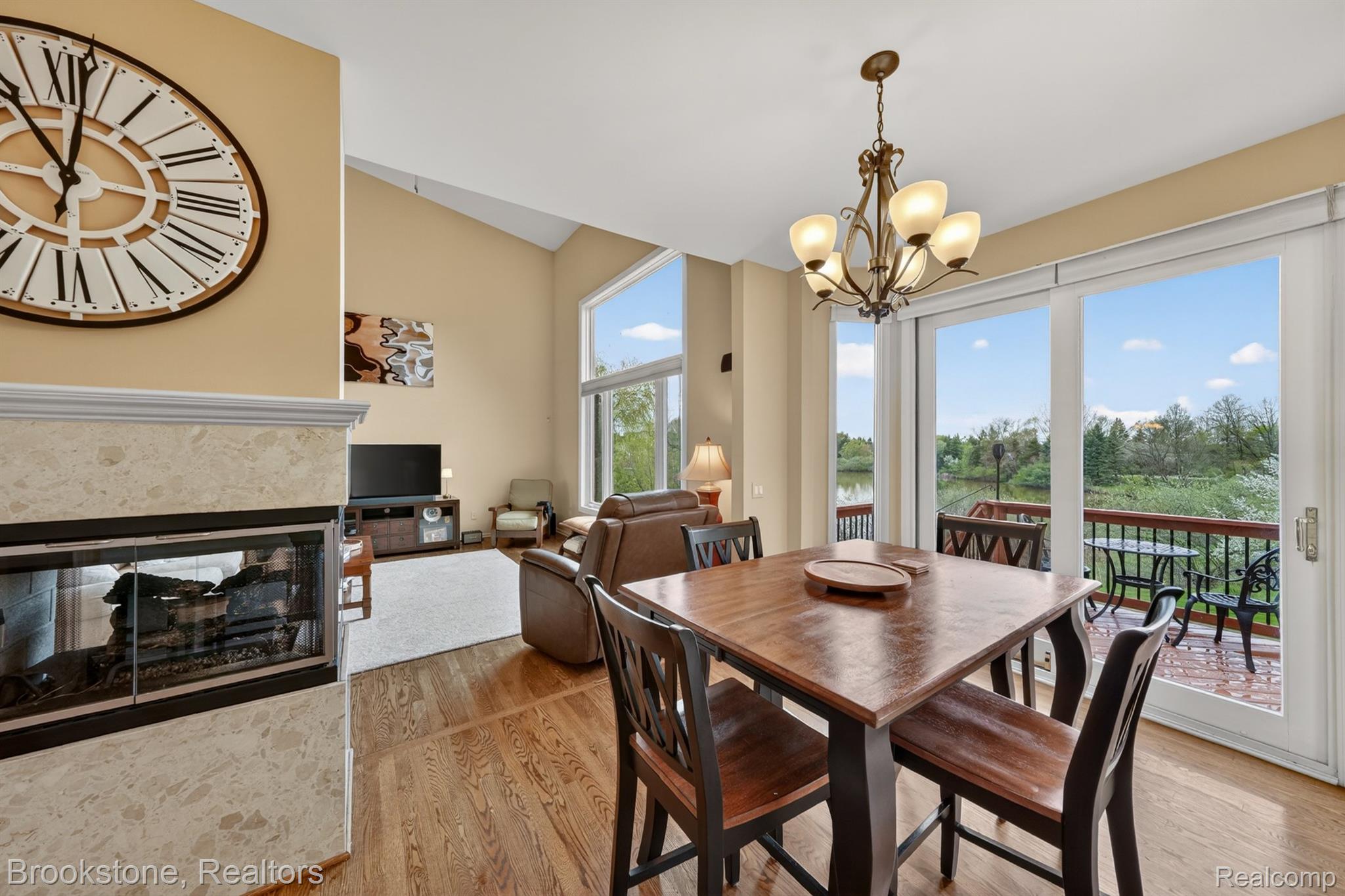 4054 Calumet Drive Rochester, MI 48306 - Photo 16 of 44 Dining space with a tiled fireplace, light wood-type flooring, vaulted ceiling, and suspended lighting