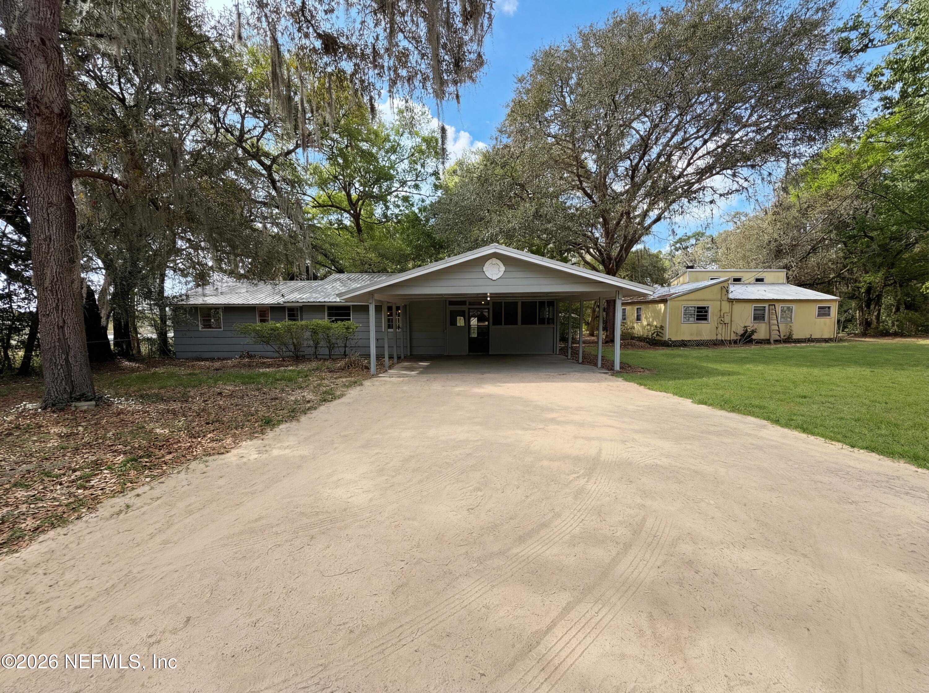 6917 Gatorbone Road Keystone Heights, FL 32656 - Photo 2 of 24 a house with trees in front of it