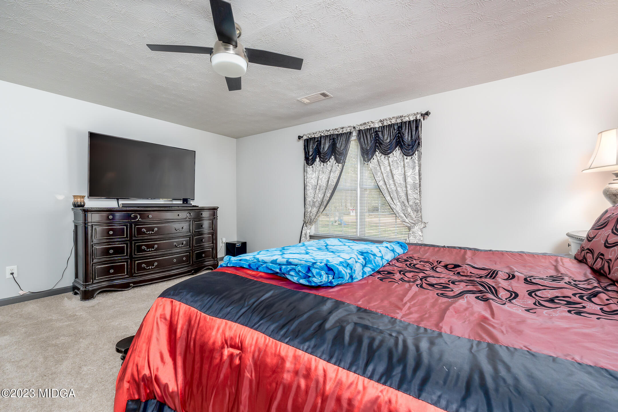 128 Samuel Barber Road Jackson, GA 30233 - Photo 16 of 27 a bedroom with a bed and a flat screen tv