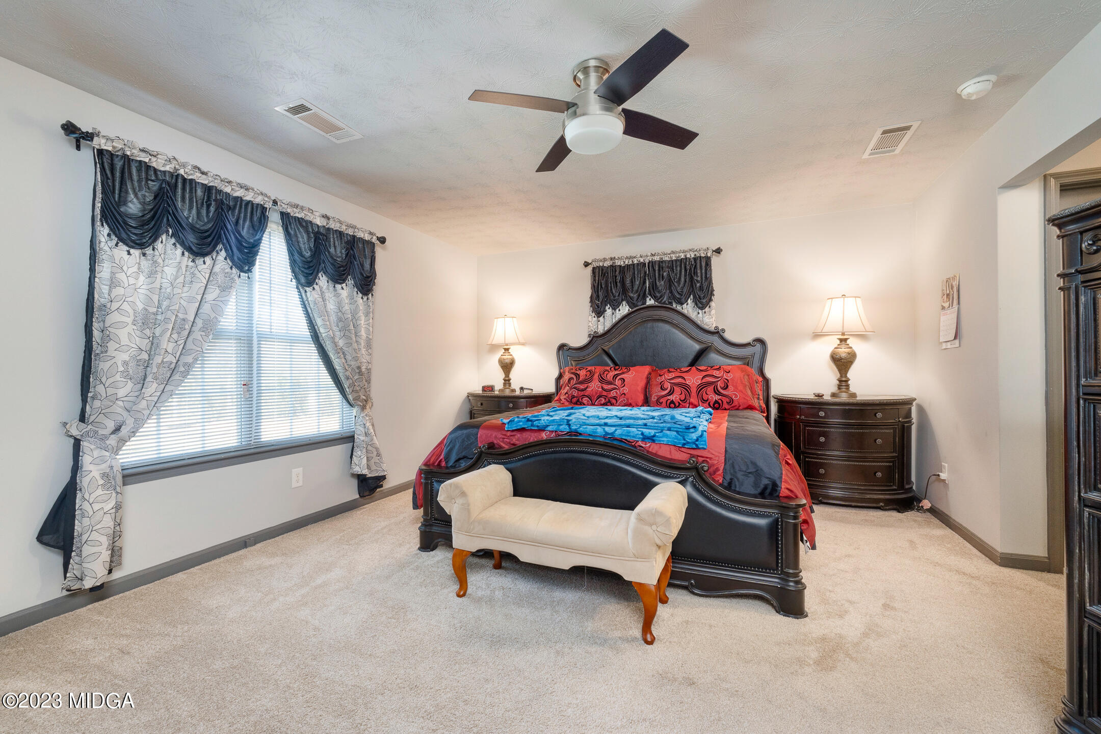 128 Samuel Barber Road Jackson, GA 30233 - Photo 17 of 27 a bedroom with a bed and a chandelier