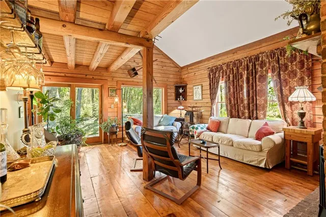 a living room with furniture a table and chairs next to a window