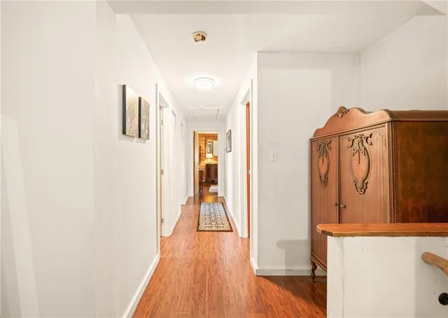 a spacious bedroom with a bed and wooden floor
