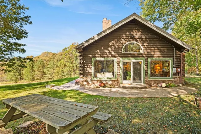 a view of swimming pool with lawn chairs and large trees