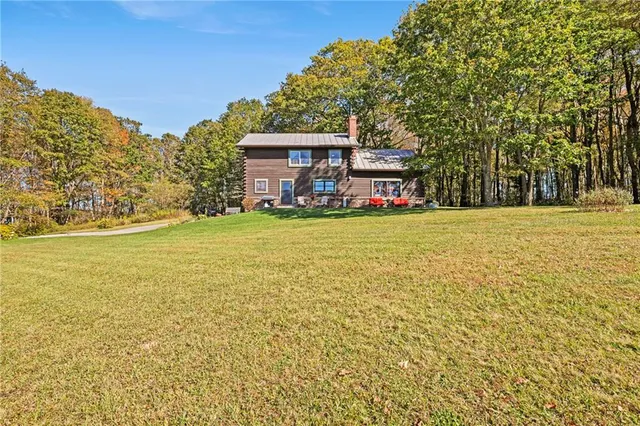 a view of a house with backyard and trees