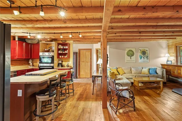 a living room with furniture a wooden floor and next to a window