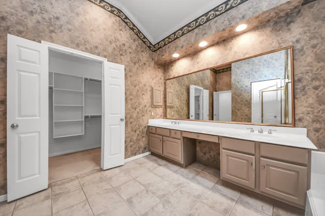 a spacious bathroom with a double vanity sink and a mirror