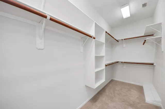a view of walk in closet with empty racks
