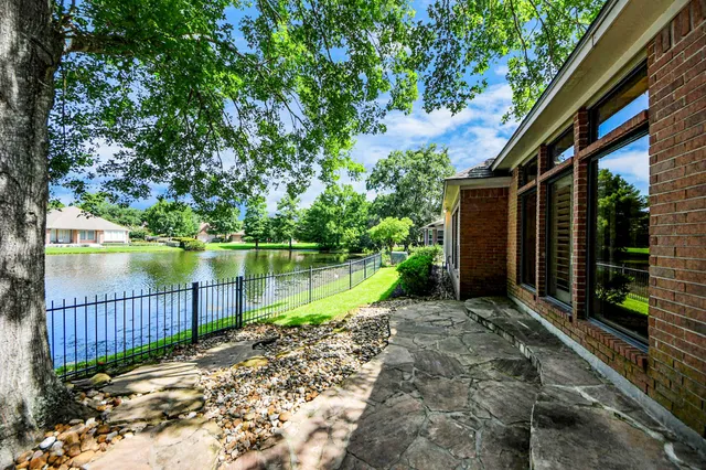 a view of a house with a yard next to a lake view