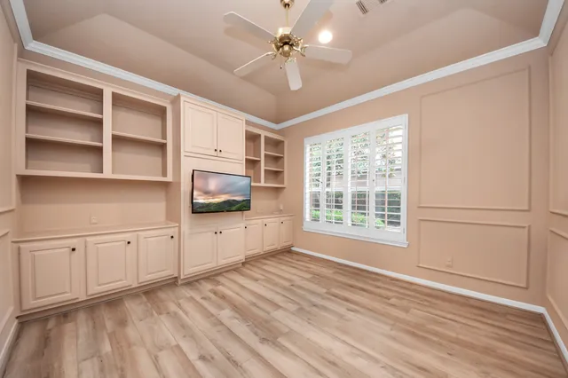 a view of an empty room with a window and a kitchen