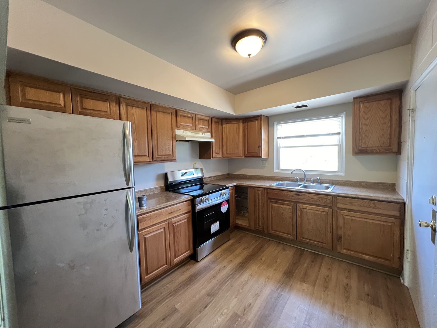 2900 Elizabeth Avenue, Unit 2S Zion, IL 60099 - Photo 3 of 12 a kitchen with stainless steel appliances granite countertop a refrigerator a sink dishwasher a stove a dining table and chairs with wooden floor