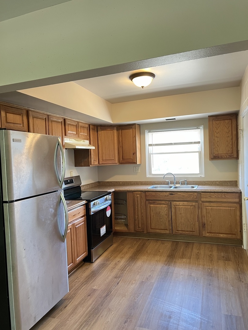 2900 Elizabeth Avenue, Unit 2S Zion, IL 60099 - Photo 4 of 12 a kitchen with stainless steel appliances granite countertop a refrigerator a sink dishwasher a stove and white countertops with wooden floor