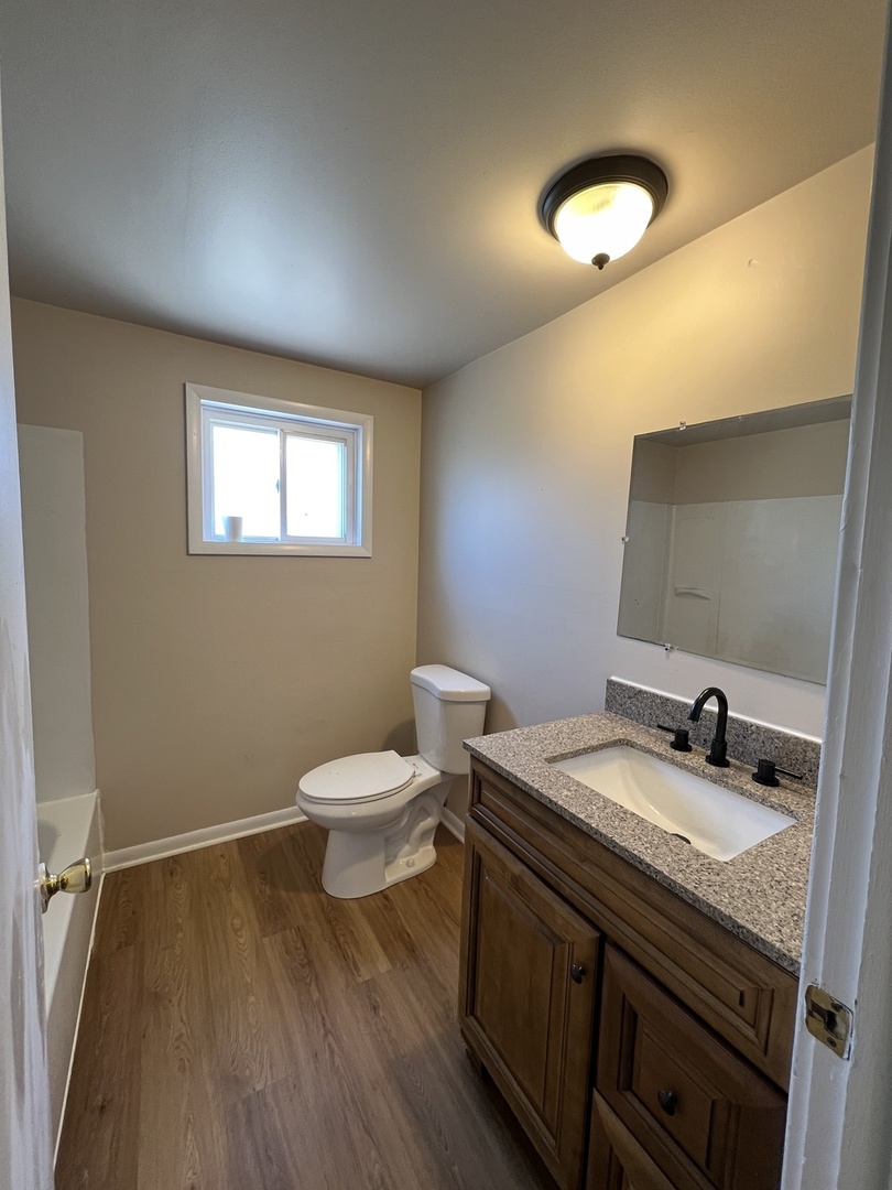 2900 Elizabeth Avenue, Unit 2S Zion, IL 60099 - Photo 5 of 12 a bathroom with a granite countertop toilet sink and mirror