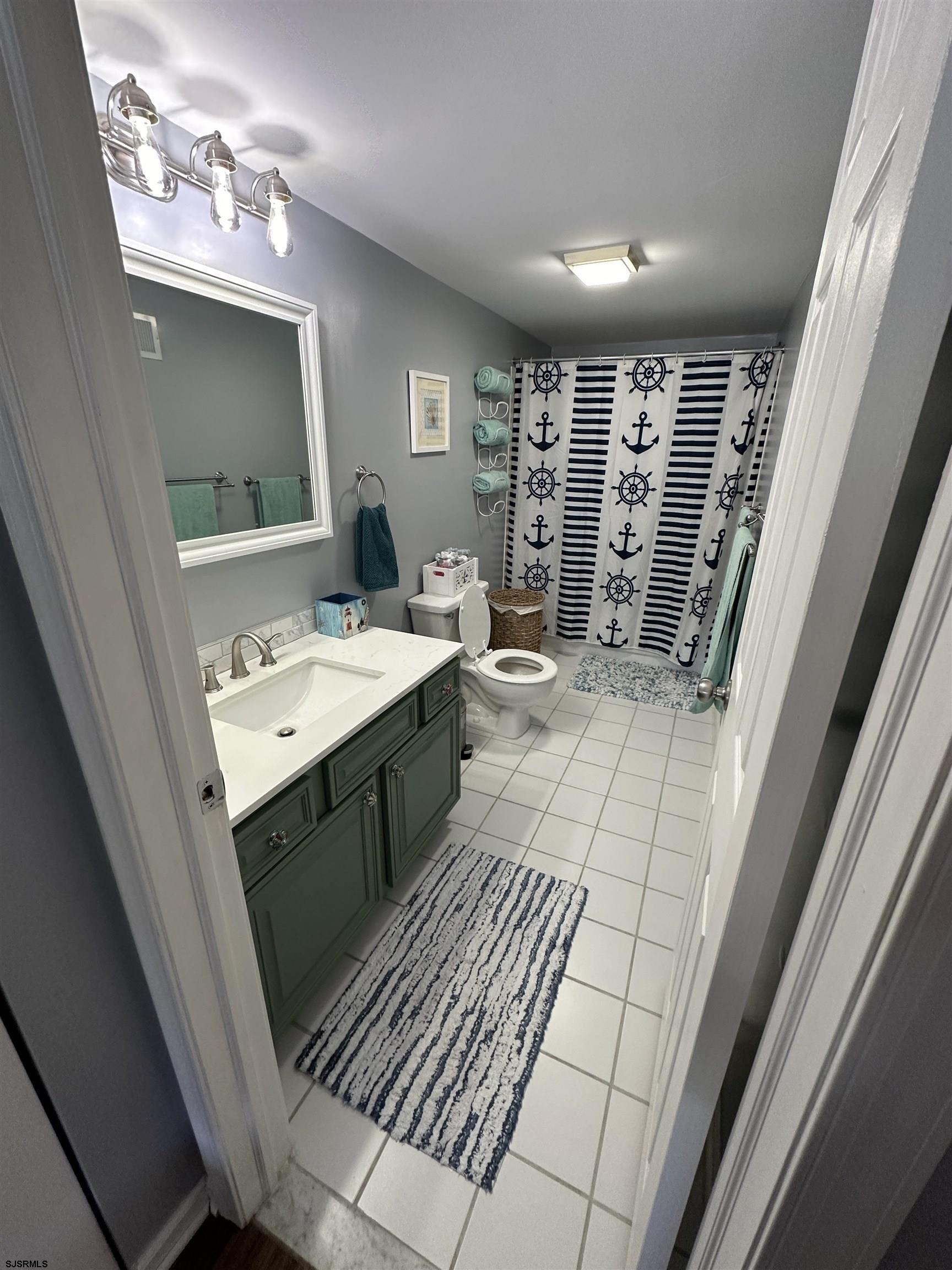4600 West Brigantine Avenue, Unit 211 Brigantine, NJ 08203 - Photo 16 of 23 a bathroom with a sink a mirror and a shower