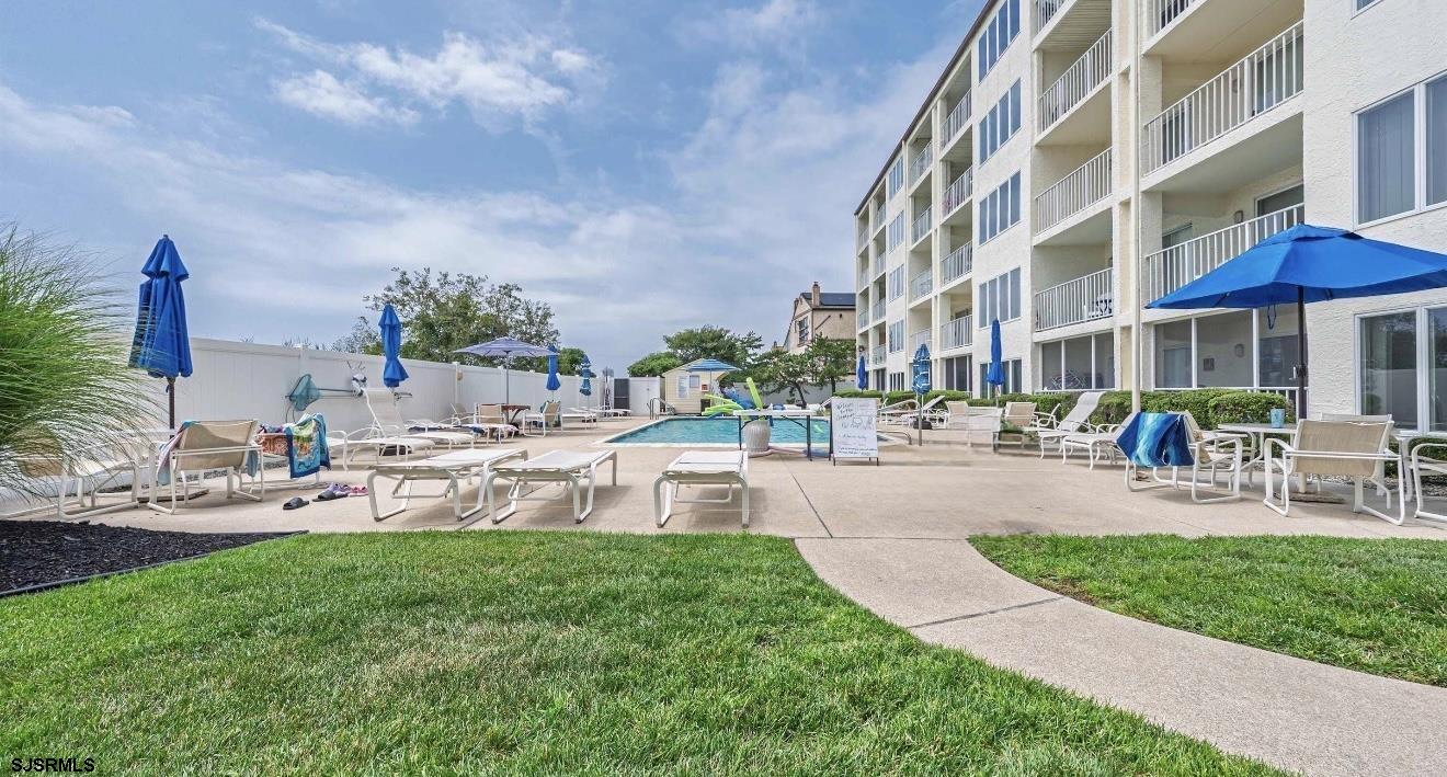 4600 West Brigantine Avenue, Unit 211 Brigantine, NJ 08203 - Photo 6 of 23 a view of a swimming pool with lawn chairs and plants