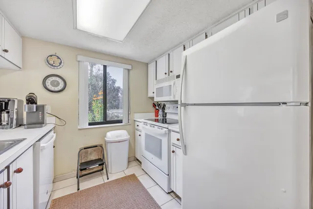 a kitchen with white cabinets and white appliances