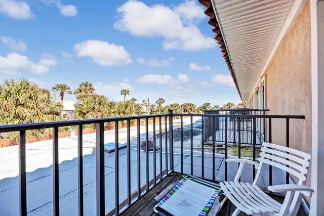 a view of a balcony with wooden chairs