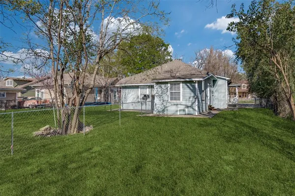 a view of a house with a big yard potted plants and large tree