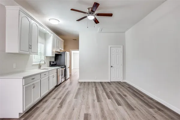 a kitchen with granite countertop a sink appliances cabinets and a counter top space