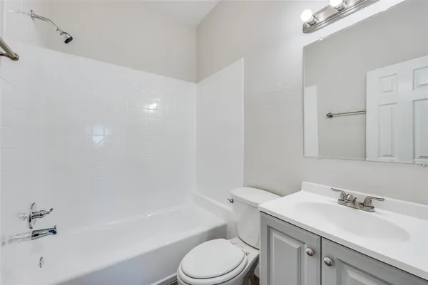 a bathroom with a sink toilet vanity and bathtub