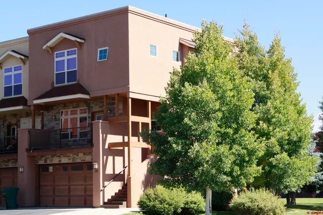 a front view of a house with a tree