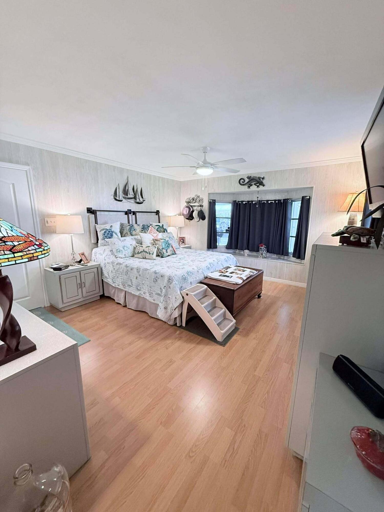 12321 Southeast 138th Avenue, Unit 216 Okeechobee, FL 34974 - Photo 13 of 34 a bedroom with a bed couch and a flat tv screen on the dresser