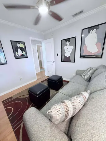 a living room with couches and a night stand