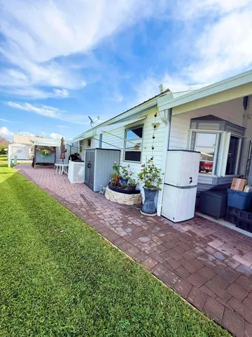 a view of a porch with chairs and potted plants