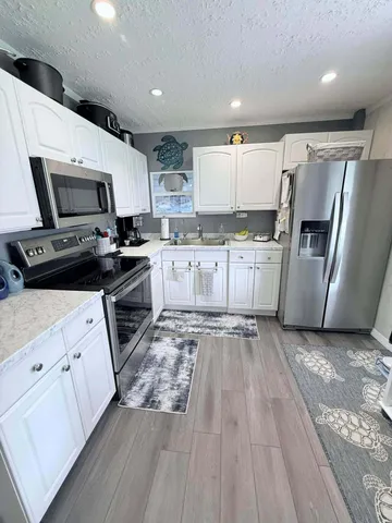 a kitchen with a sink a stove top oven and refrigerator
