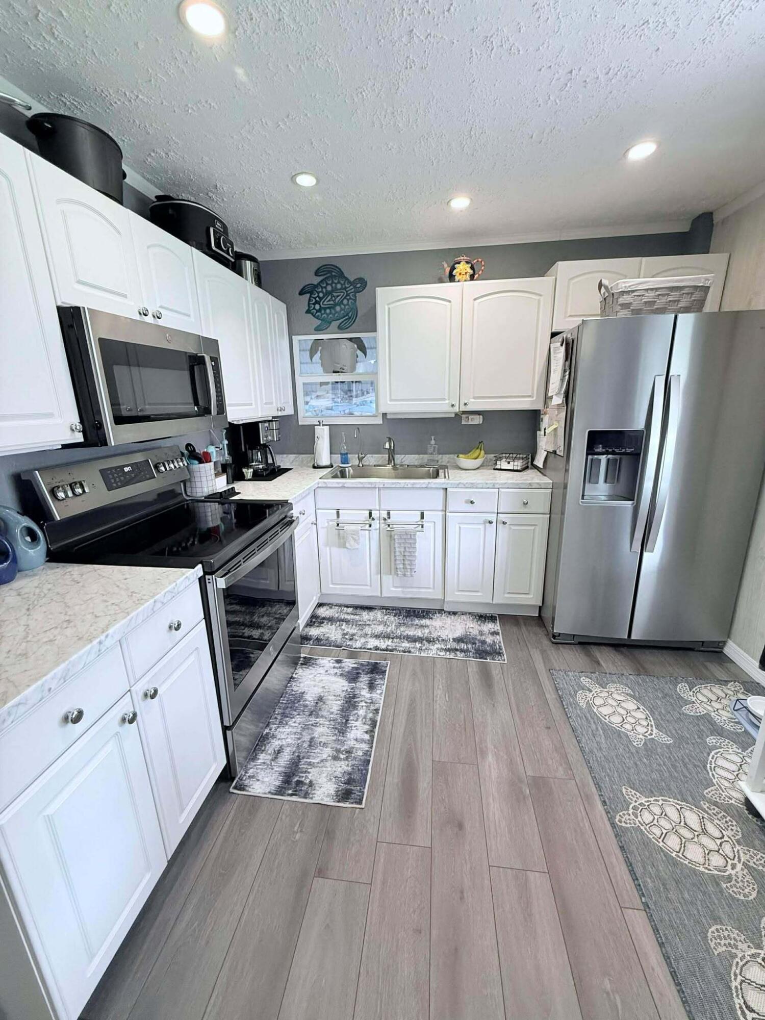 12321 Southeast 138th Avenue, Unit 216 Okeechobee, FL 34974 - Photo 4 of 34 a kitchen with a sink a stove top oven and refrigerator
