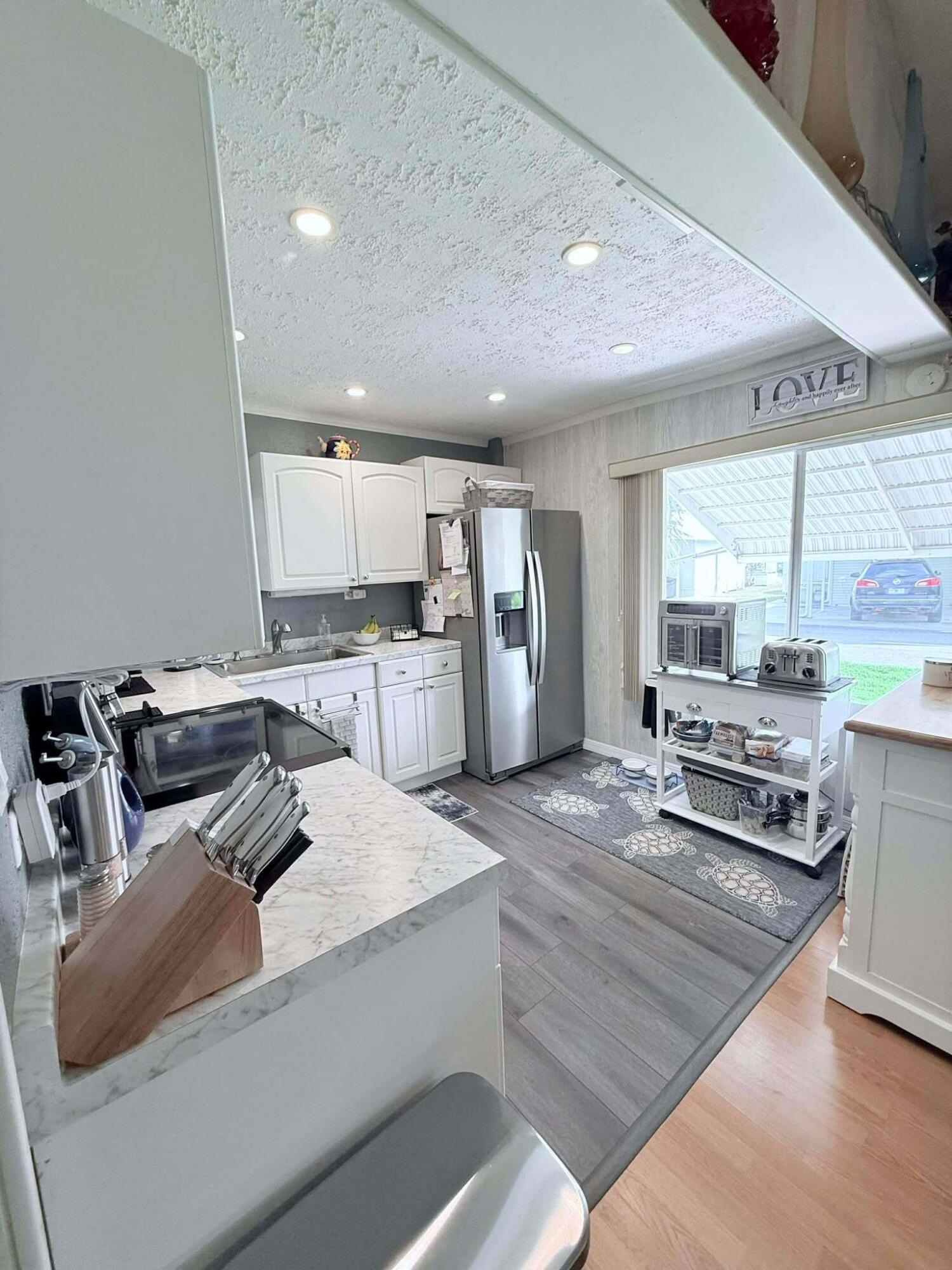 12321 Southeast 138th Avenue, Unit 216 Okeechobee, FL 34974 - Photo 5 of 34 a kitchen with stainless steel appliances granite countertop a sink stove and refrigerator