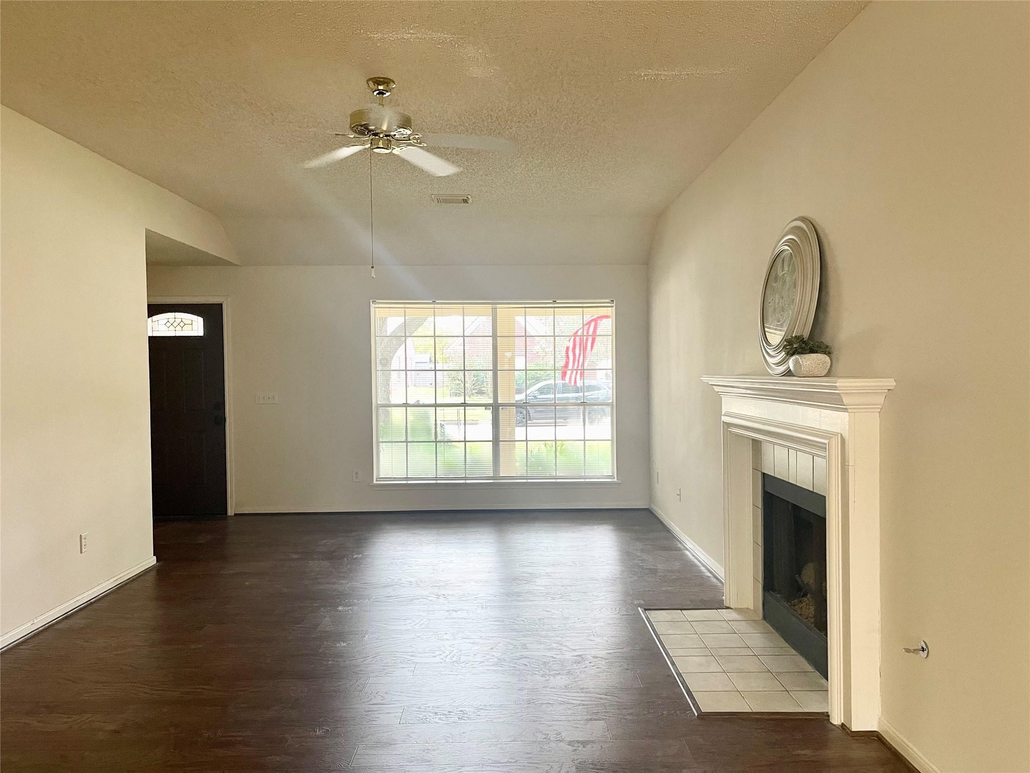 8910 Driftstone Drive Spring, TX 77379 - Photo 5 of 20 a view of an empty room with a fireplace and wooden floor
