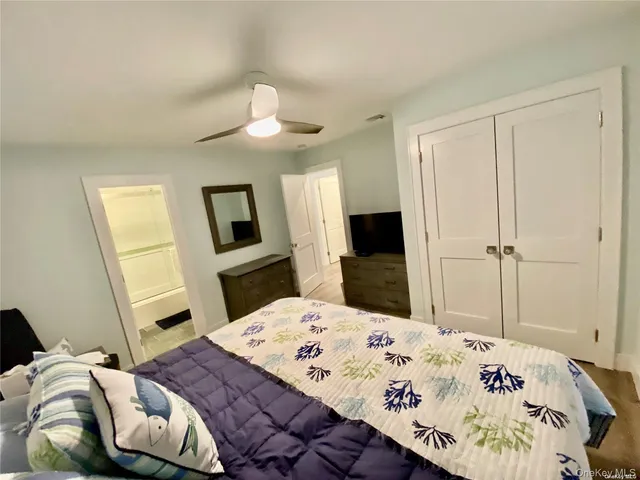 a bedroom with a bed and a flat tv screen on the dresser