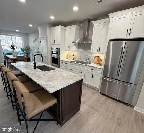 a kitchen with stainless steel appliances granite countertop a refrigerator a stove a sink a microwave and a refrigerator