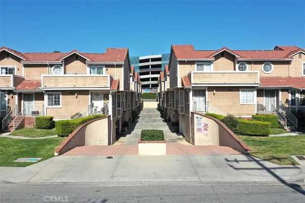 a view of multiple houses with a yard and potted plants