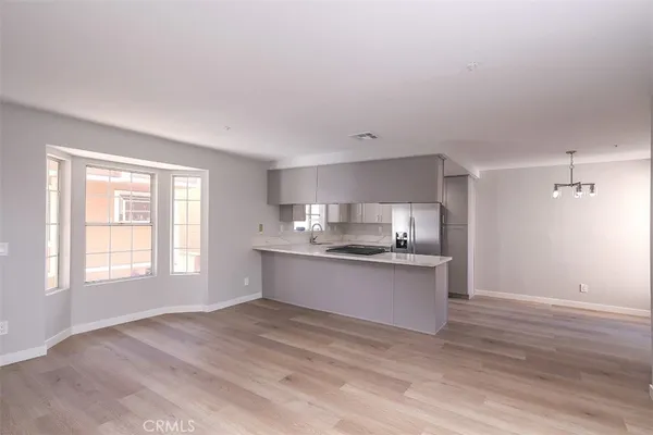 a kitchen with stainless steel appliances granite countertop a sink cabinets and wooden floor