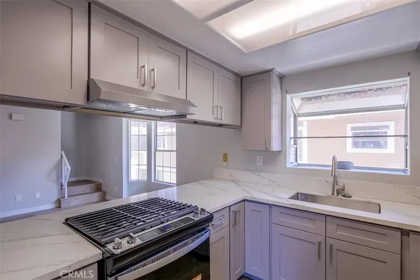 a kitchen with a sink stove top oven and cabinets