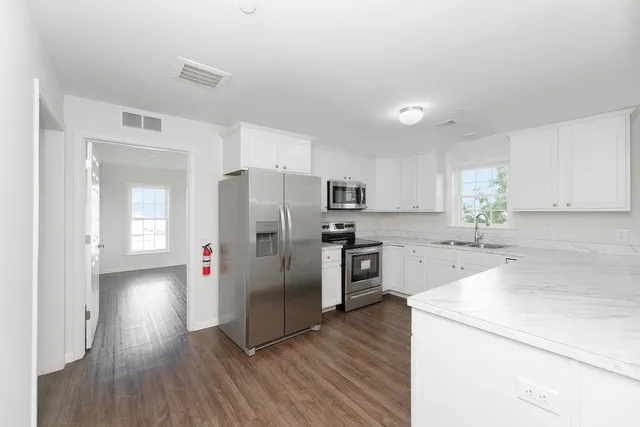 a kitchen with stainless steel appliances a refrigerator and a stove top oven