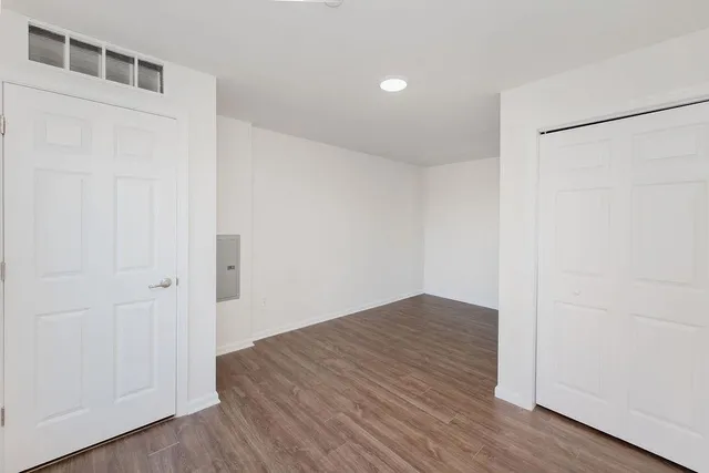 a view of an empty room with wooden floor