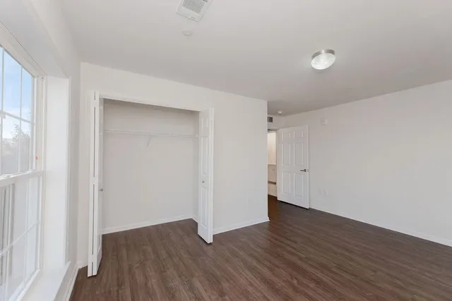 a view of an empty room with wooden floor