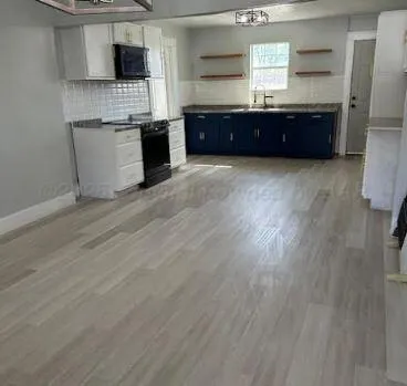a large kitchen with kitchen island granite countertop a sink and a stove top oven