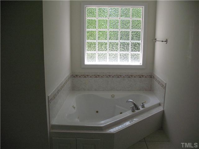5701 Novaglen Road Durham, NC 27712 - Photo 8 of 12 a white bath tub sitting in a bathroom next to a window