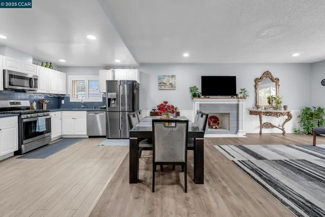 a living room with furniture a flat screen tv and kitchen view