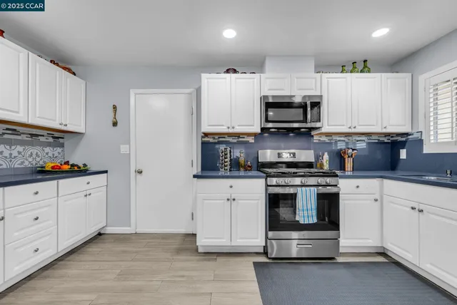 a kitchen with stainless steel appliances granite countertop a stove a sink and a refrigerator