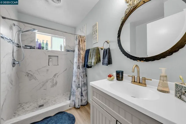 a bathroom with a sink vanity mirror and tub